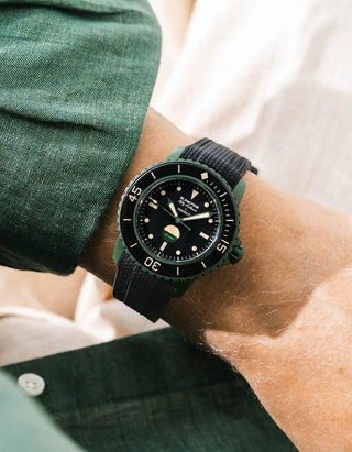 Black Vertech rubber strap for Blancpain x Swatch Scuba Fifty Fathoms Green Abyss – worn on wrist with dark green linen shirt, black dial and black bezel with green case, front angle view