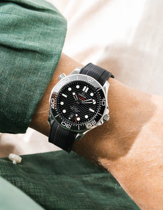 Black Vertech rubber strap for Omega Seamaster Diver 300 42mm – worn on wrist with dark green linen jacket, black dial and bezel, front angle view