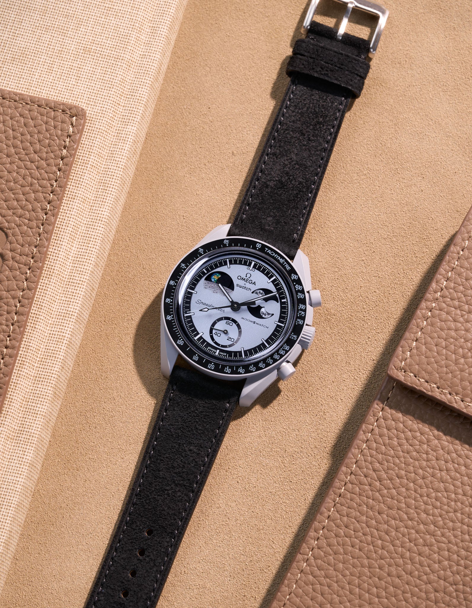 Flat lay Moonswatch Mission to Earthphase with Black suede leather strap