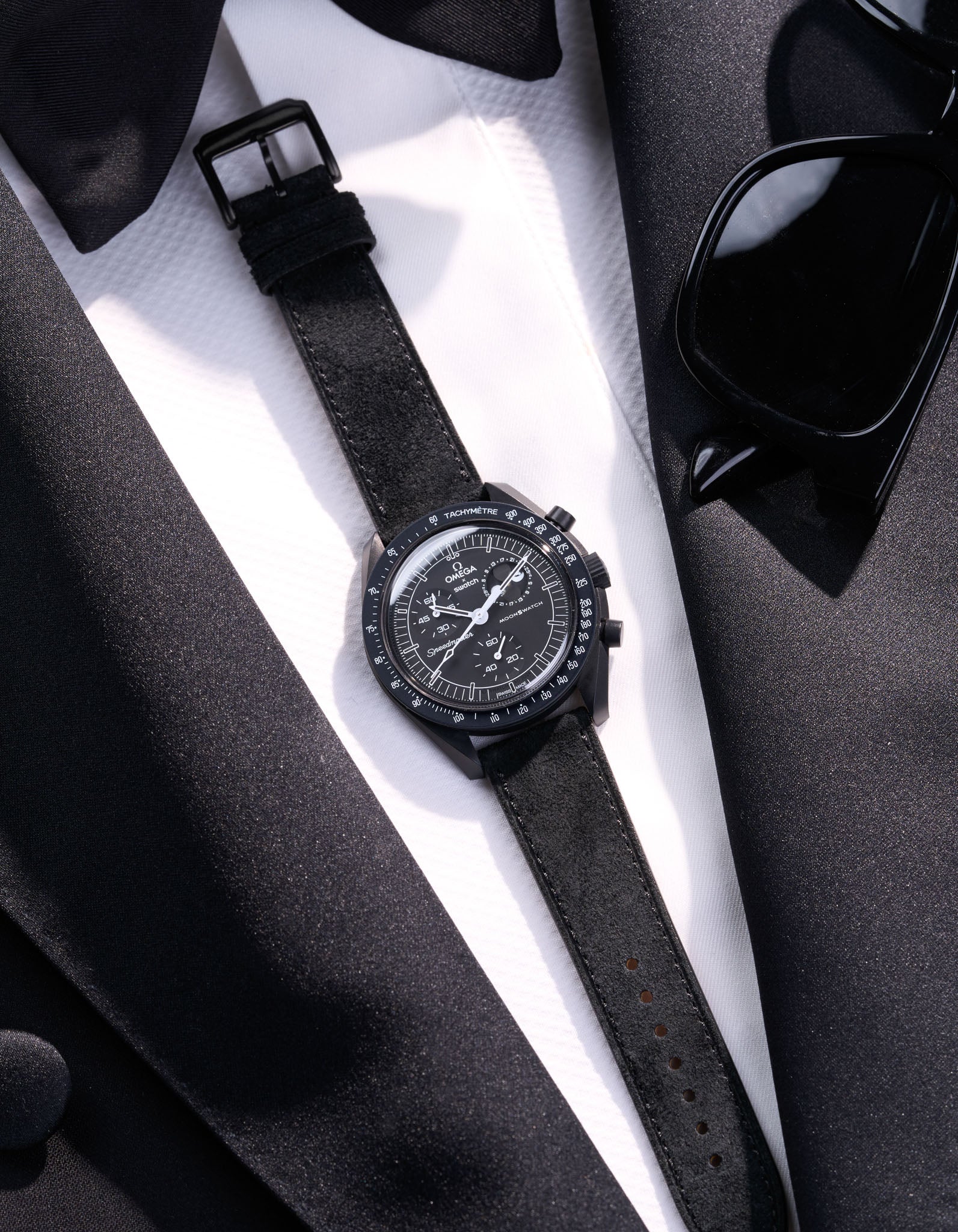 Flat lay Moonswatch Mission to the Moonphase New Moon with Black suede leather strap