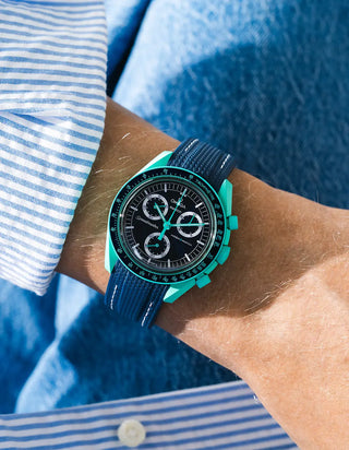 Blue rubber strap with blue stitching for OMEGA x Swatch MoonSwatch Mission On Earth – Polar Lights, worn on the wrist in a lifestyle shot with clothing visible