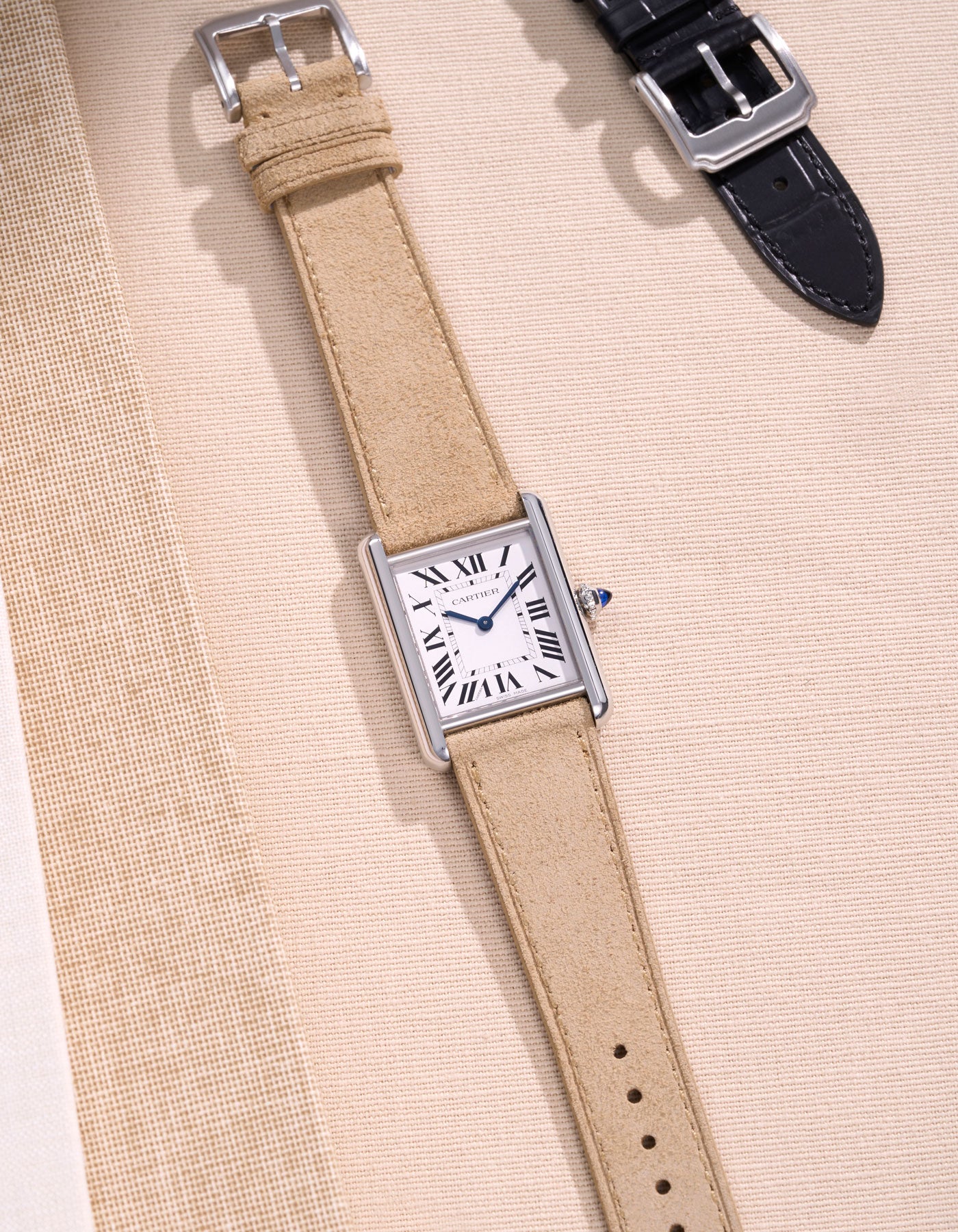 Cartier watch with beige suede strap.