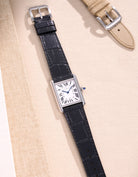 Cartier watch with sleek black alligator leather strap on a beige background