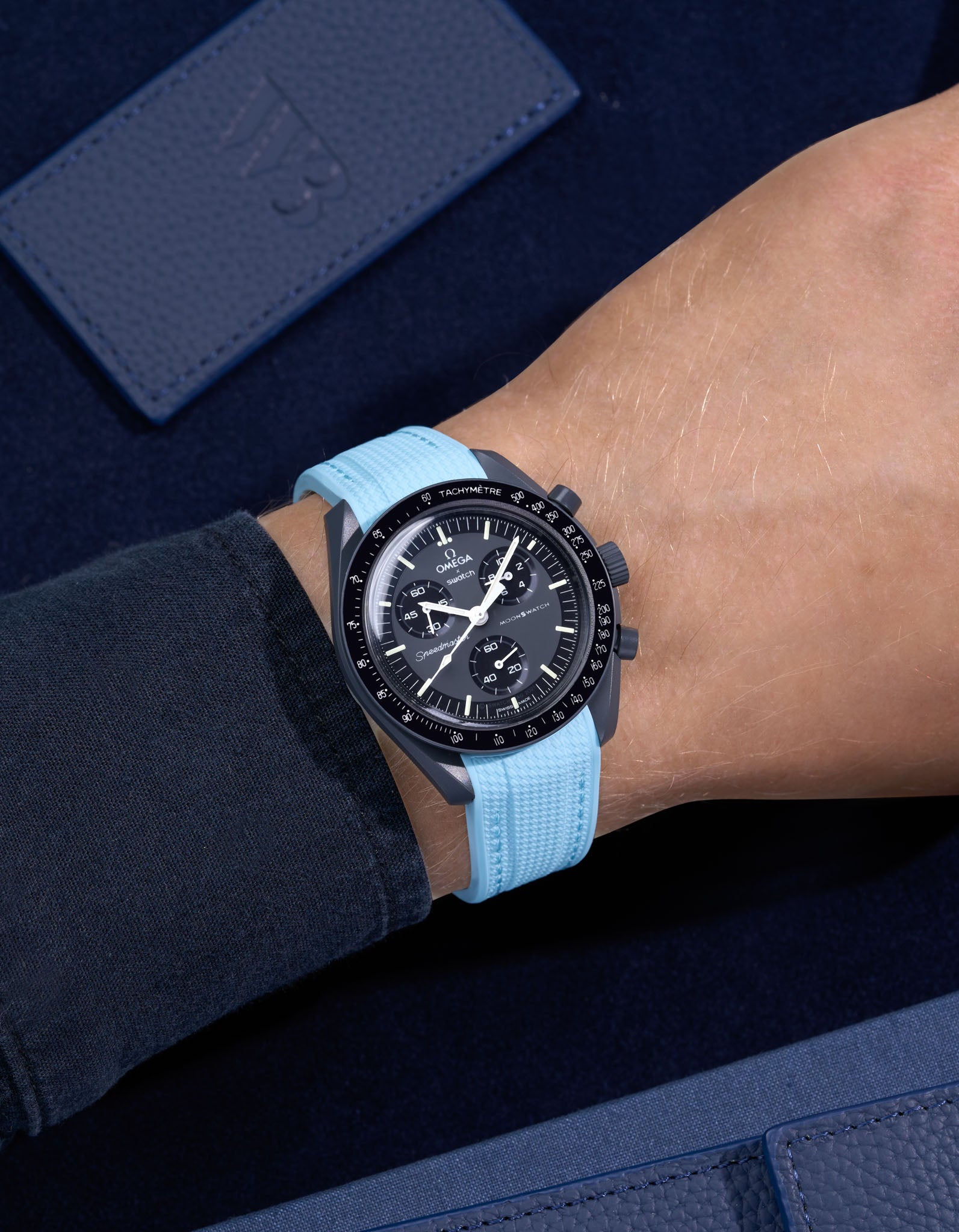 MoonSwatch Mission to Mercury on wrist with vertech turquoise rubber strap and a dark blue shirt