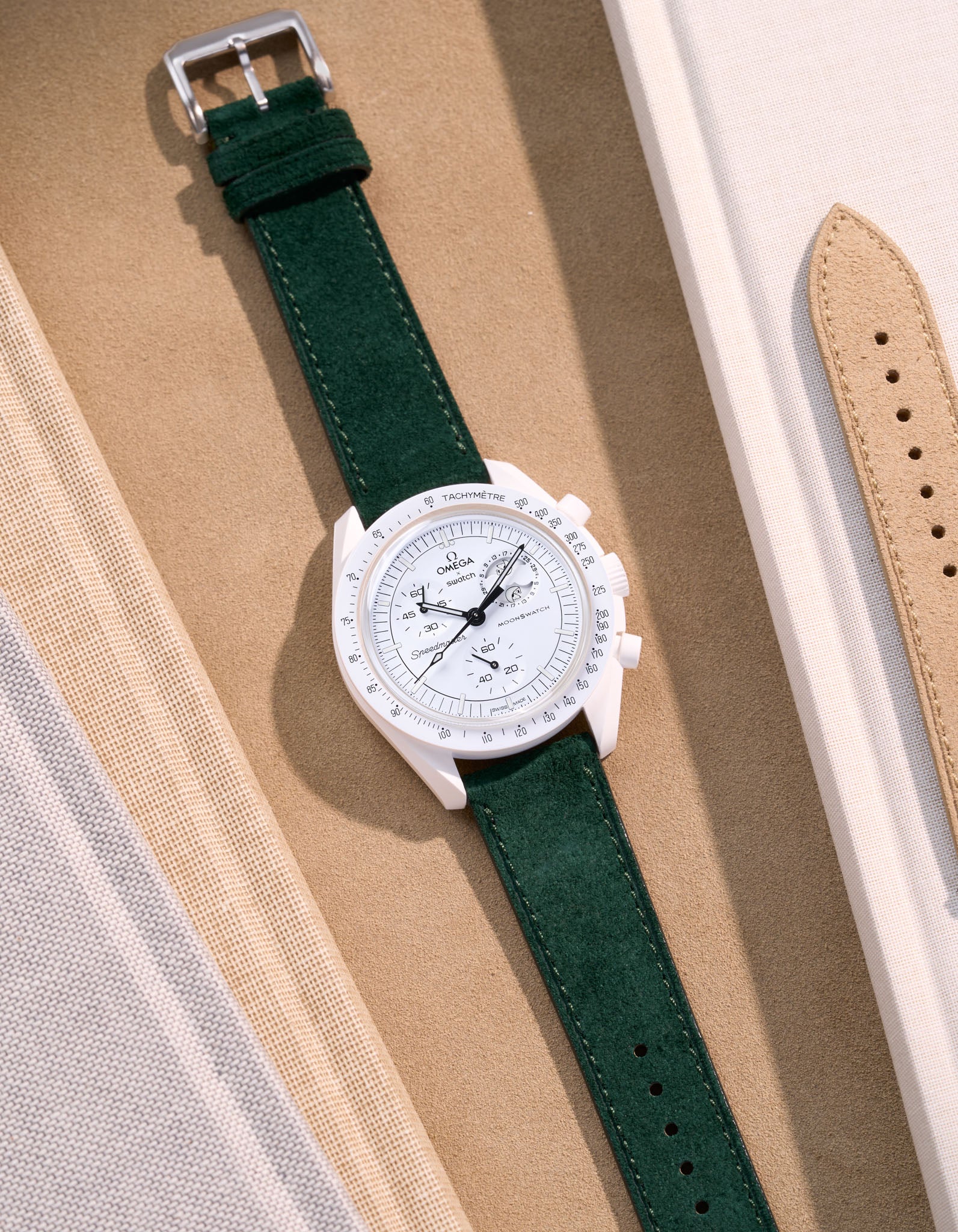 Flat lay Moonswatch Mission to the Moonphase Full Moon with Dark Green suede leather strap