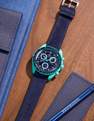 Flat lay Moonswatch Mission on Earth Polar Lights with Dark Blue suede leather strap