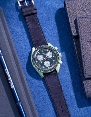 Flat lay Moonswatch Mission on Earth with Dark Blue suede leather strap