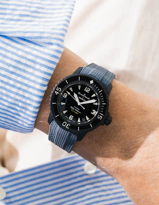 Dark grey Vertech rubber strap for Blancpain x Swatch Scuba Fifty Fathoms The Ocean of Storms – worn on wrist with light blue striped shirt, black dial and black bezel with black case, side angle view
