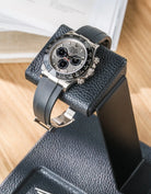 Close-up of a chronograph watch resting on the soft calfskin leather cushion of the double watch stand