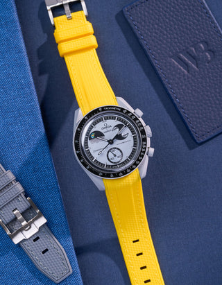 Flat lay of Omega X Swatch MoonSwatch Mission to EarthPhase with yellow rubber strap, watch facing up with clasp visible
