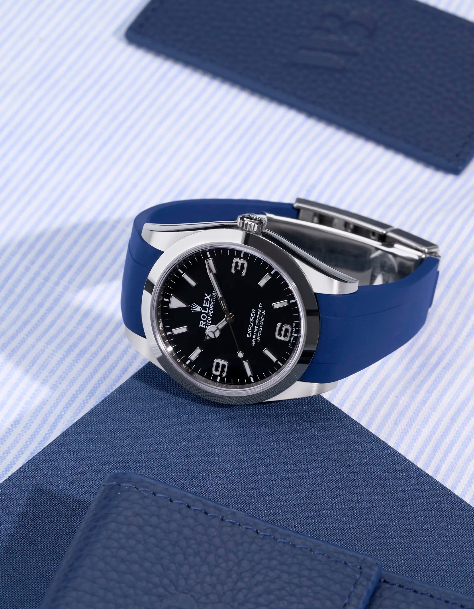 Rolex Explorer 214270 on blue FKM rubber strap integrated with original clasp – angled studio shot