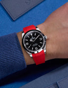 Red integrated rubber strap with original clasp on Rolex Explorer 214270 – wrist shot with navy blue tones