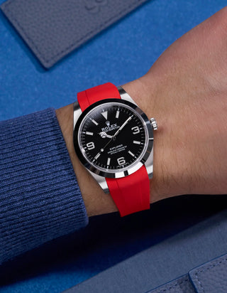 Red integrated rubber strap with original clasp on Rolex Explorer 214270 – wrist shot with navy blue tones