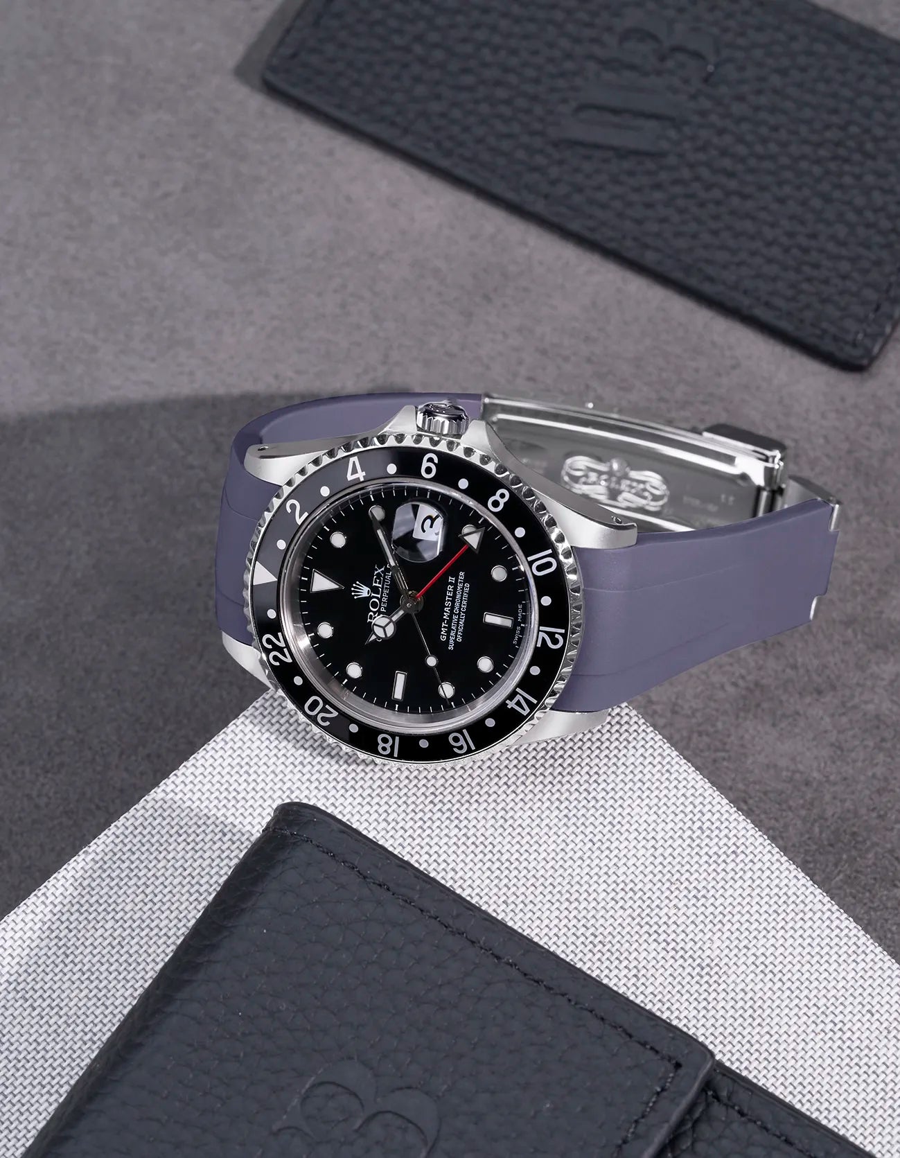Rolex GMT-Master II 16710 and 16713 fitted with grey rubber strap and original clasp – flat lay on textured surface