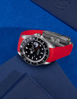 Rolex GMT-Master II 16710 and 16713 fitted with red FKM rubber strap and original clasp – flat lay on blue background