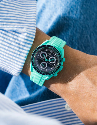 Green rubber strap for OMEGA x Swatch MoonSwatch Mission On Earth – Polar Lights, worn on the wrist in a lifestyle shot with clothing visible