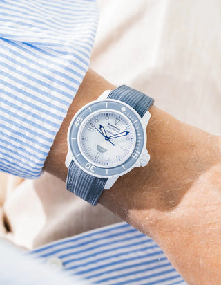 Grey Vertech rubber strap for Blancpain x Swatch Scuba Fifty Fathoms Antarctic Ocean – worn on wrist with light blue striped shirt, white dial and grey bezel with white case, front angle view