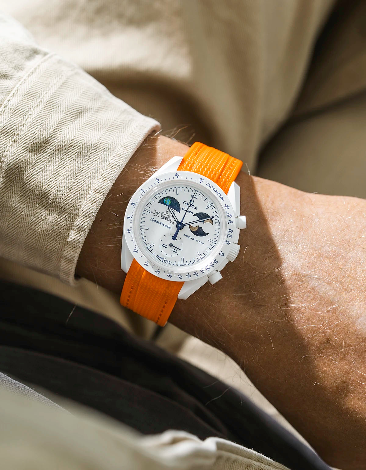 Orange rubber strap on Moonswatch Moonshine Gold Cold Moon wrist shot with beige shirt