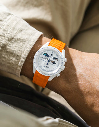 Orange rubber strap on Moonswatch Moonshine Gold Cold Moon wrist shot with beige shirt