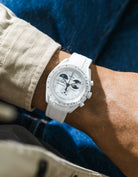 White rubber strap on Moonswatch Moonshine Gold Cold Moon watch wrist shot with beige shirt