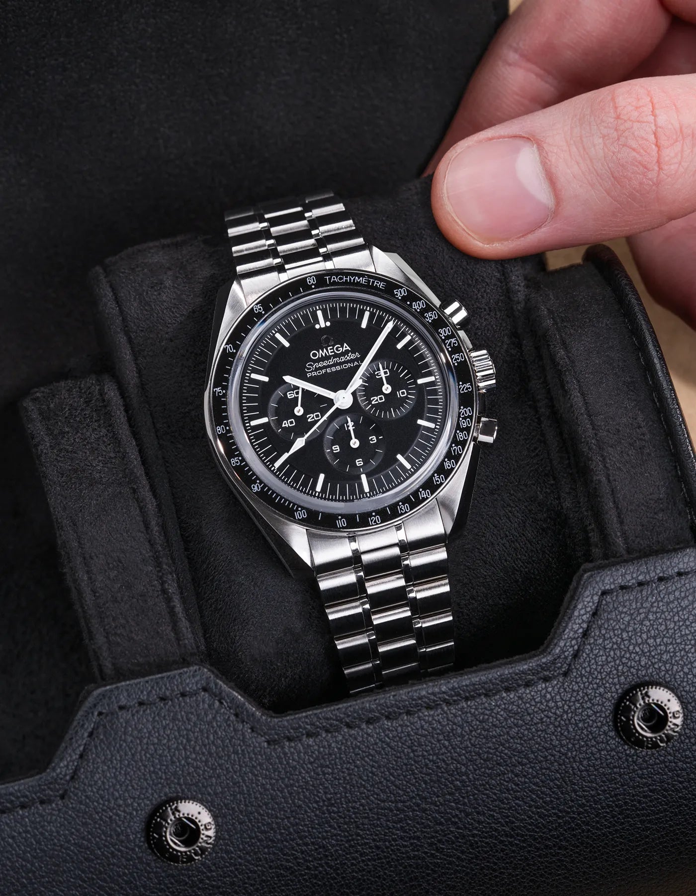 Black watch roll with Sliding System, showcasing an Omega Speedmaster stainless steel watch on a soft velvet sliding cushion for secure and stylish storage