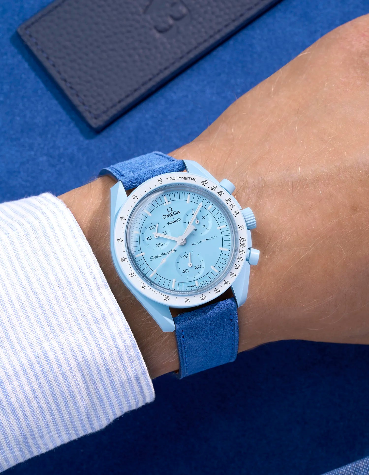 Omega X Swatch Mission to Uranus with Ocean Blue suede leather strap worn on wrist – styled shot in earthy neutral tones