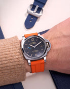 Panerai Luminor GMT Black Dial with Orange Rubber Strap on Wrist – Swiss Made Panerai watch with a bold 24mm orange rubber strap, designed for both aesthetics and durability. This replacement uhrenband enhances the watch’s visual appeal, providing a fresh, modern touch that is perfect for active lifestyles and individuals who enjoy vibrant accessories. The stainless steel case and GMT function make it a versatile timepiece for world travelers.