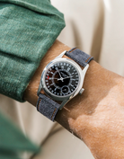 Patek Calatrava on a black denim leather watch strap from Wristbuddys on a persons wrist wearing a green shirt