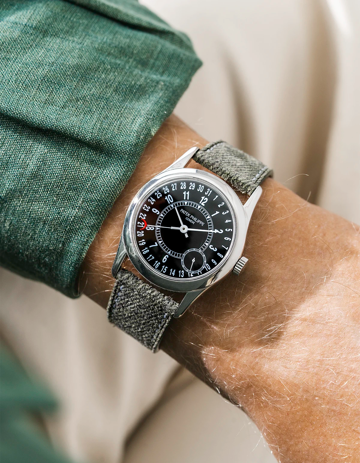 Patek Calatrava on a green denim leather watch strap from Wristbuddys on a persons wrist wearing a green shirt