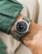 Patek Calatrava on a green denim leather watch strap from Wristbuddys on a persons wrist wearing a green shirt