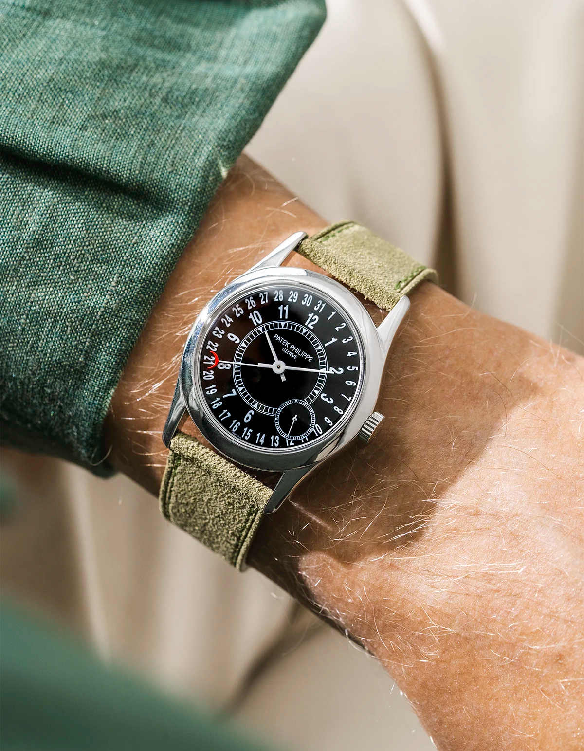 Patek with green suede watch strap from Wristbuddys on a person's wrist, close-up shot.