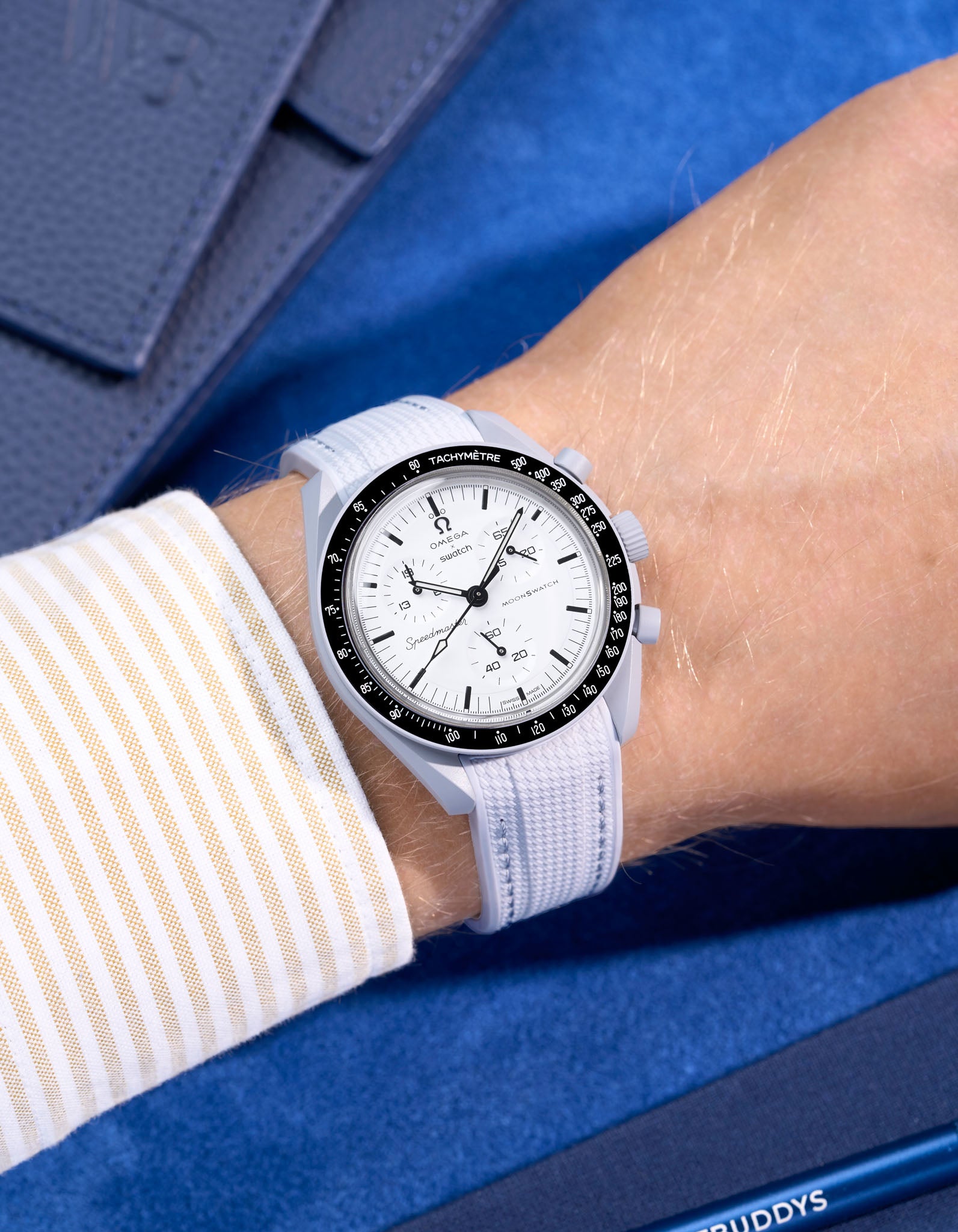 Omega X Swatch MoonSwatch 1965 watch with grey strap and white face on a blue background