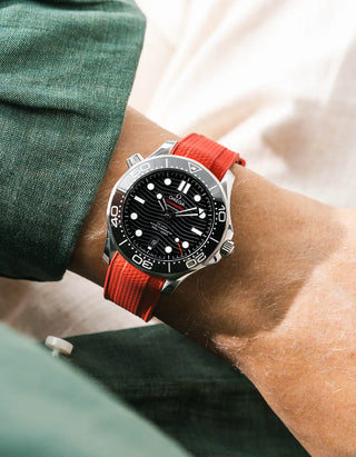 Red Vertech rubber strap for Omega Seamaster Diver 300 42mm – worn on wrist with dark green linen jacket, black dial and bezel, side angle view
