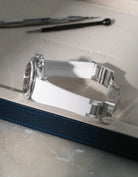 White textured FKM rubber strap for Rolex Daytona 16520, custom integrated fit with original clasp, resting on a white leather valet tray.