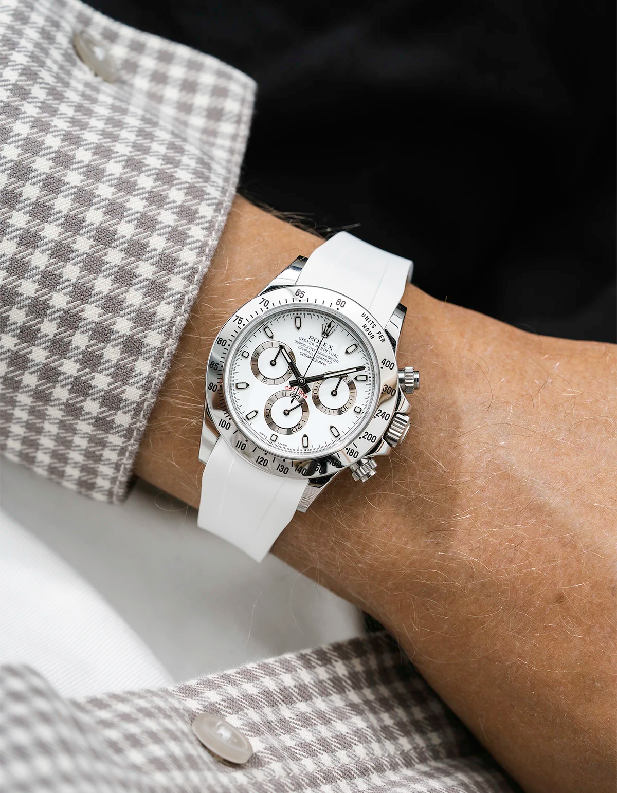 Close-up of a person wearing a white Rolex Daytona watch with a white jacket sleeve and a FKM rubber watch strap from Wristbuddys