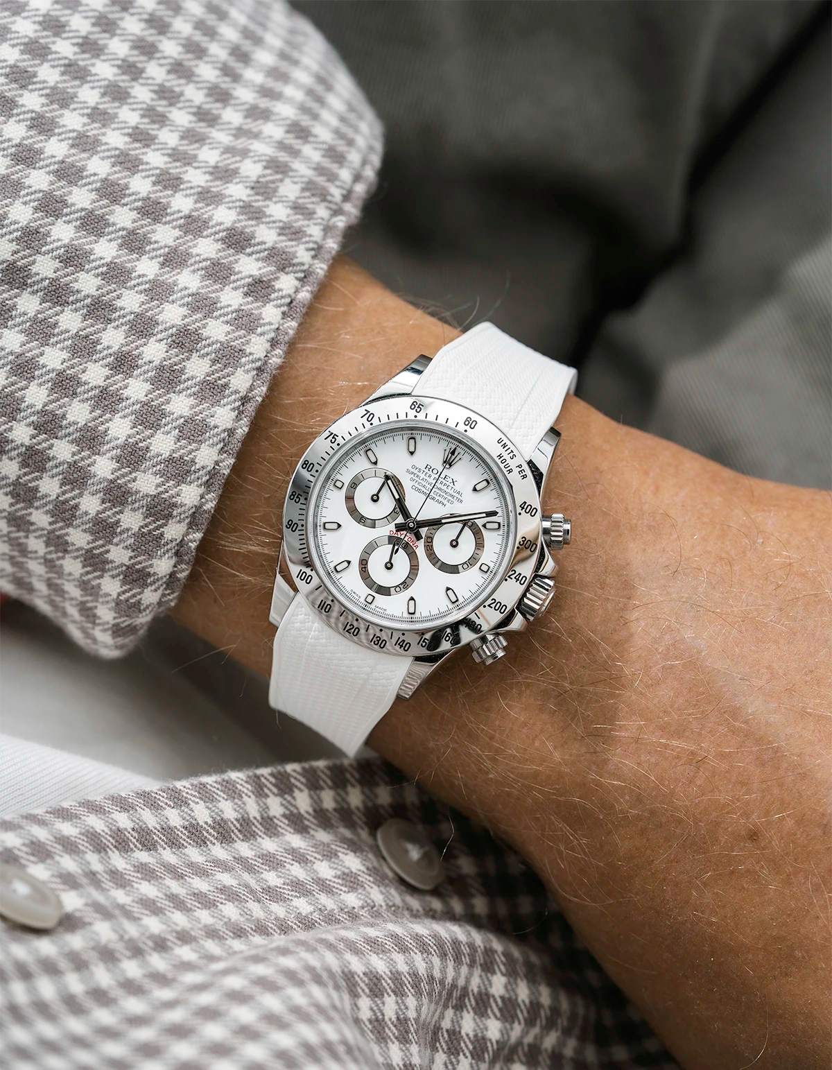Close-up of a person wearing a white Rolex Daytona watch with a beige white stiped shirt sleeve and a white vertech FKM rubber watch strap from Wristbuddys