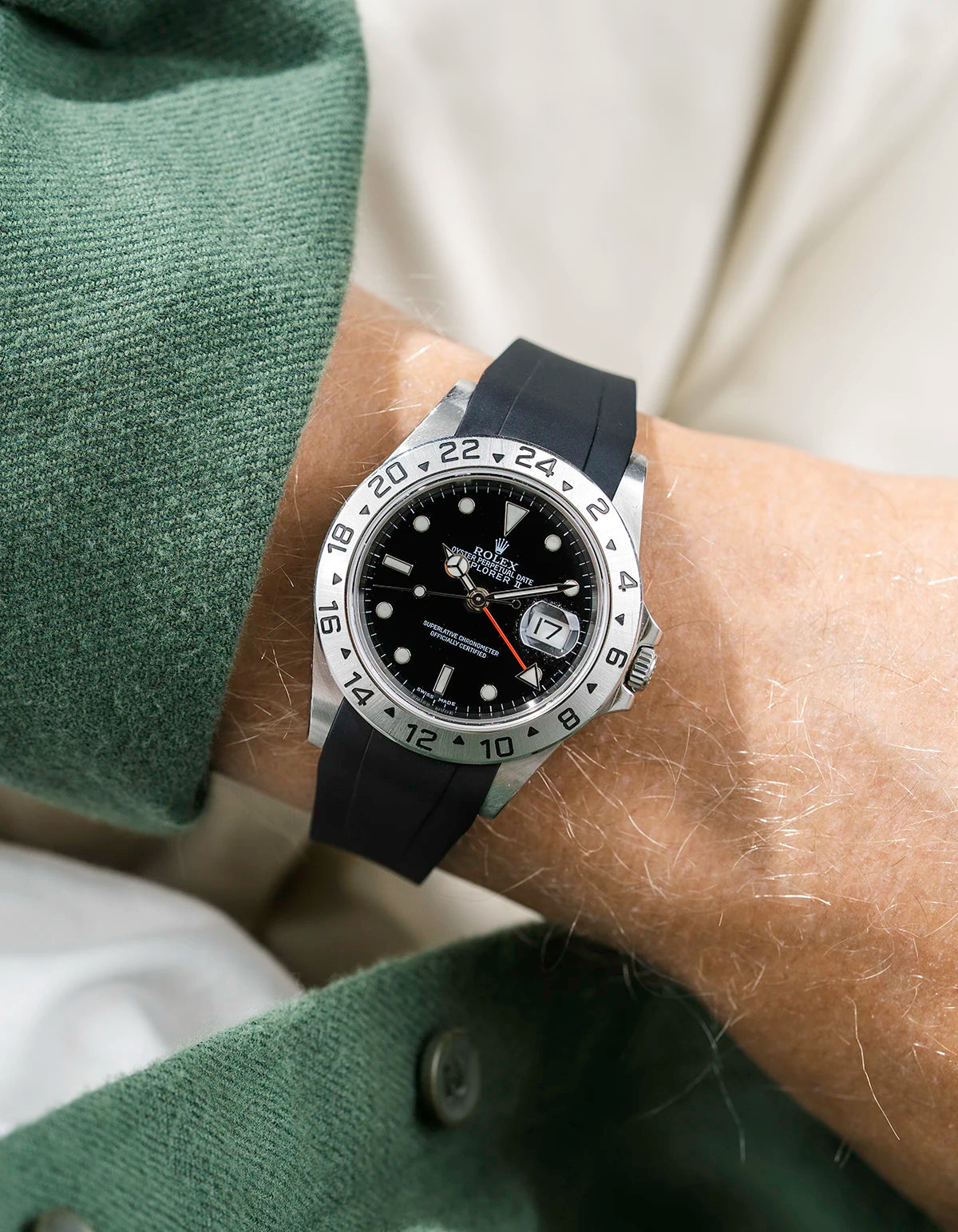 Close-up of a person wearing a Rolex Explorer 2 16570 model watch with a green jacket sleeve and a black FKM rubber watch strap from Wristbuddys