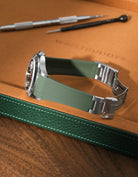 Military Green FKM rubber strap for Rolex Explorer II 16570, integrated case fit for original clasp, resting on a leather watch tray with tools.