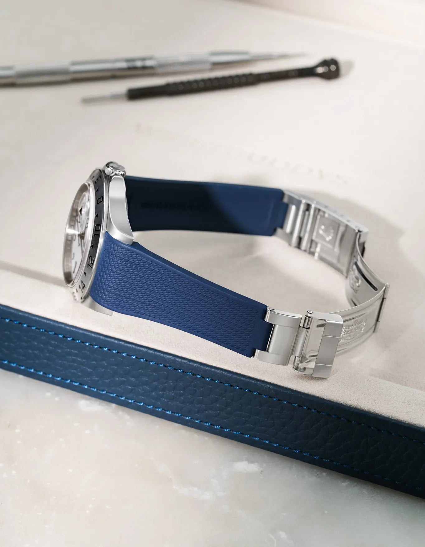 Navy Blue Vertech FKM rubber strap for Rolex Explorer II 16570, seamless integration with original clasp, resting on a blue leather valet tray.