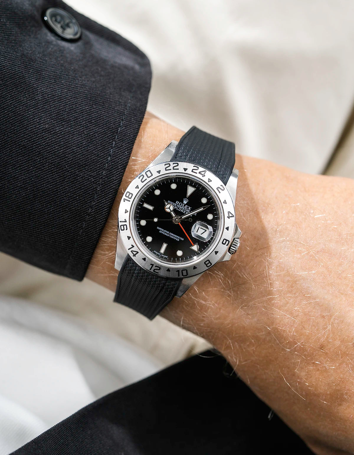 Close-up of a person wearing a Rolex Explorer 2 16570 model watch with a black jacket sleeve and a black Vertech FKM rubber watch strap from Wristbuddys