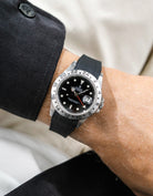 Close-up of a person wearing a Rolex Explorer 2 16570 model watch with a black jacket sleeve and a black Vertech FKM rubber watch strap from Wristbuddys