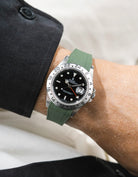 Close-up of a person wearing a Rolex Explorer 2 16570 model watch with a black jacket sleeve and a green Vertech FKM rubber watch strap from Wristbuddys