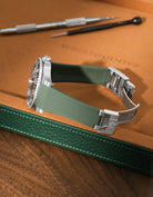 Military Green Vertech FKM rubber strap for Rolex GMT-Master II 116710, integrated case fit for original clasp, resting on a leather watch tray.