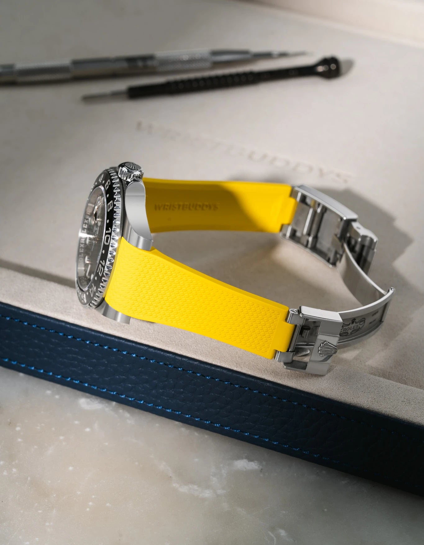 Yellow integrated FKM rubber watch band for Rolex GMT-Master II 116710, Vertech textured finish with original clasp, resting on a white valet tray.