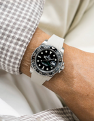 Close-up of a person wearing a Rolex GMT Master Green hand 116710 model watch with  white and beige jacket sleeve and a beige FKM rubber watch strap from Wristbuddys