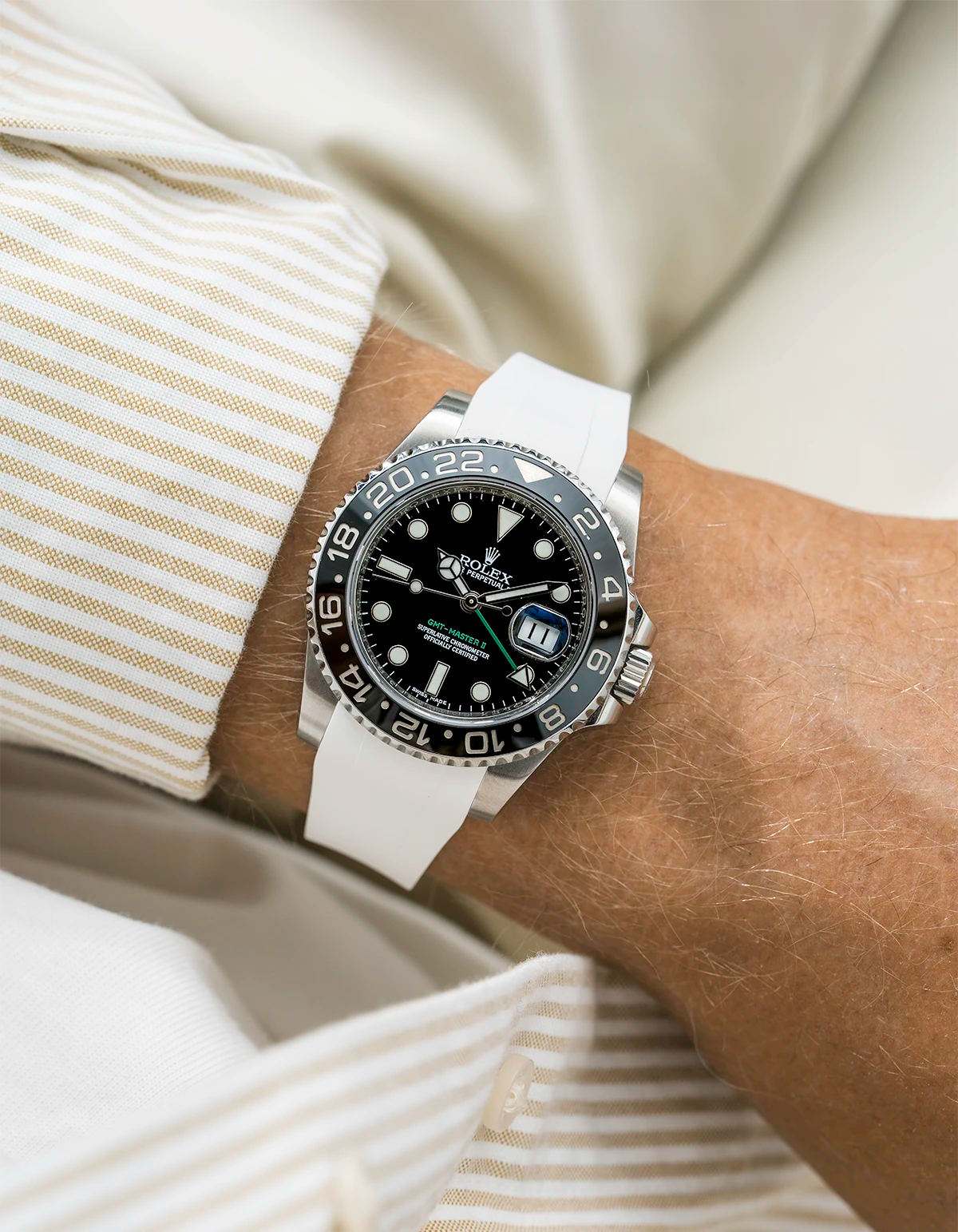 Close-up of a person wearing a Rolex GMT Master Green hand 116710 model watch with  white beige jacket sleeve and a white FKM rubber watch strap from Wristbuddys