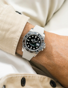 Close-up of a person wearing a Rolex GMT Master Green hand 116710 model watch with beige jacket sleeve and a beige vertech FKM rubber watch strap from Wristbuddys