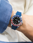 Close-up of a person wearing a Rolex GMT Master 2 Pepsi model watch with a blue jacket sleeve and a blue FKM rubber watch strap from Wristbuddys