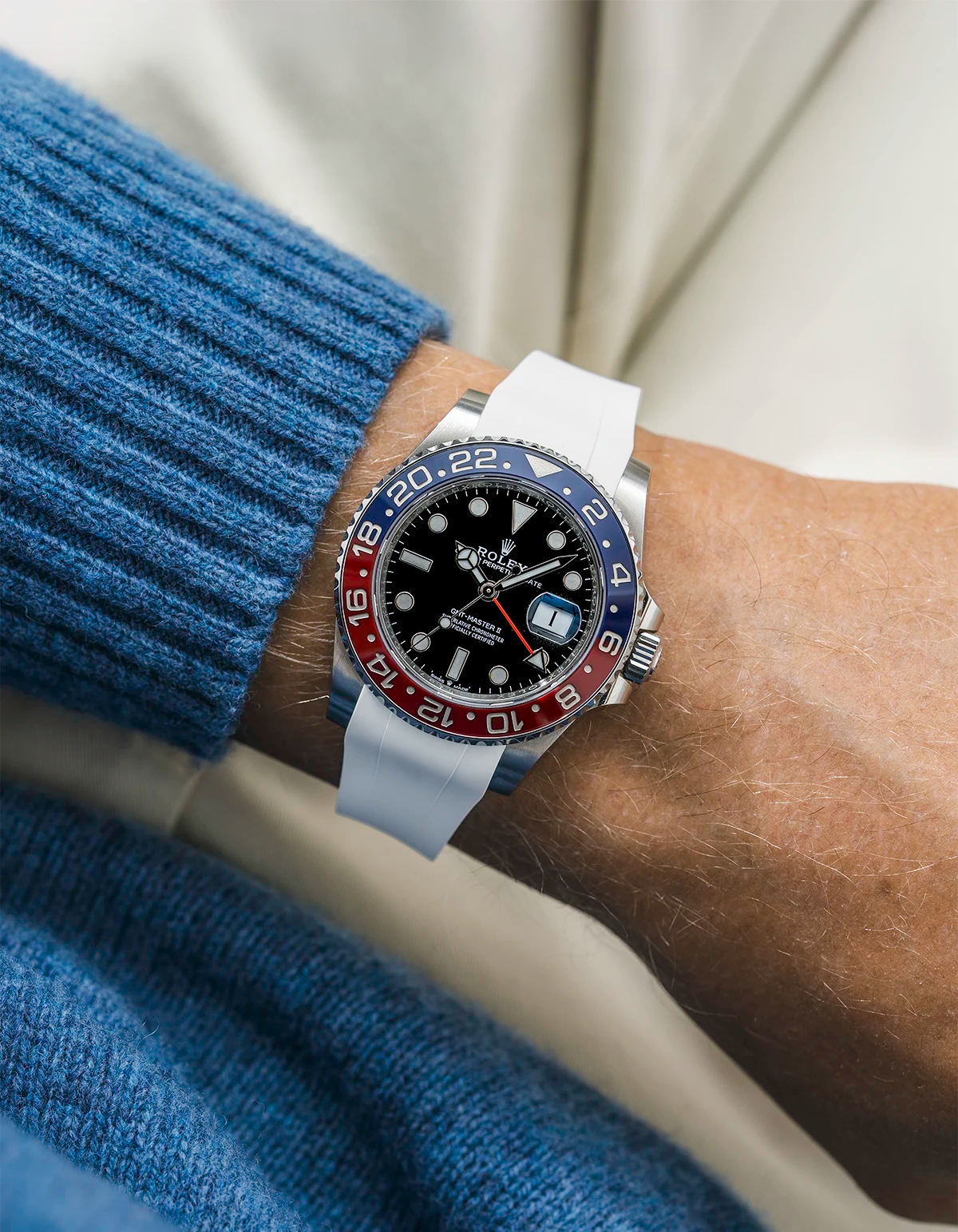 Close-up of a person wearing a Rolex GMT Master 2 Pepsi model watch with a blue jacket sleeve and a white FKM rubber watch strap from Wristbuddys