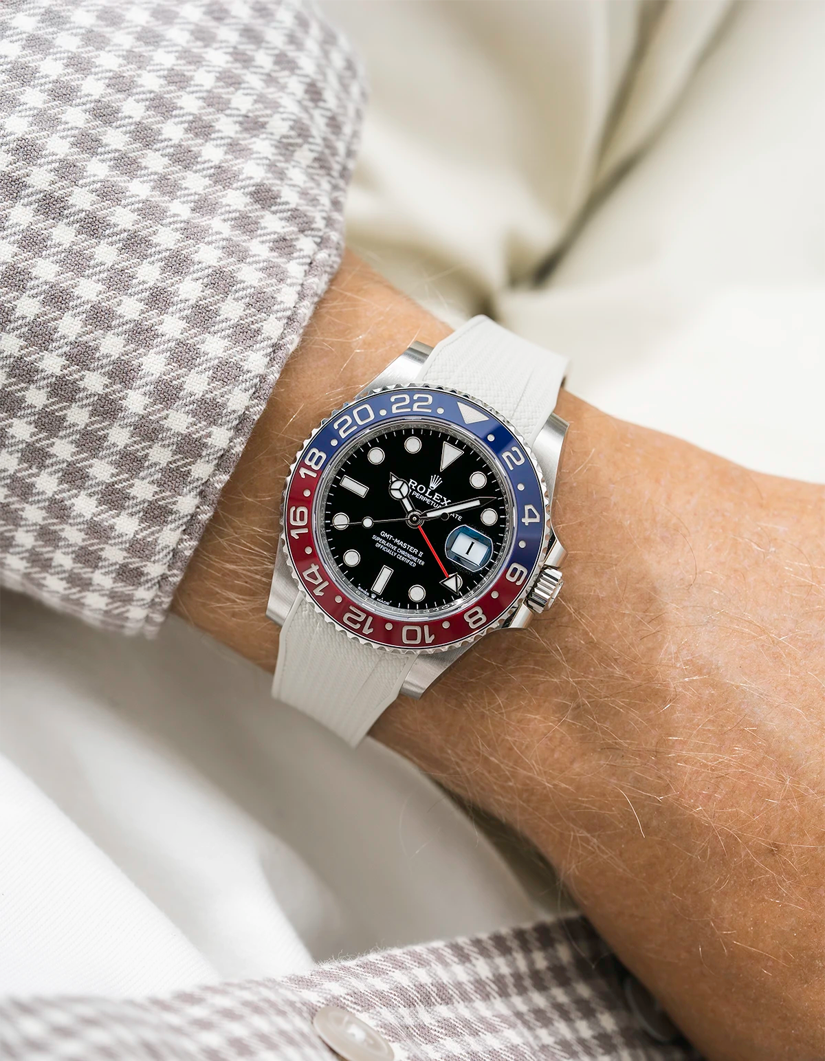 Close-up of a person wearing a Rolex GMT Master 2 Pepsi model watch with  beige white jacket sleeve and a beige vertech FKM rubber watch strap from Wristbuddys